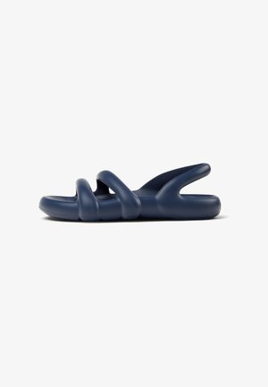 Sandalias azul marino con un material suave y flexible, con un diseño de tres tiras y parte trasera abierta para transpirabilidad. Textura suave en todo.