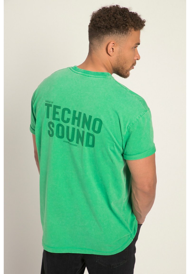 Camiseta de algodón verde con mangas cortas, que presenta el texto "MUNDO DEL SONIDO TECNOLÓGICO" en verde oscuro en la parte posterior. Ajuste casual, textura suave.