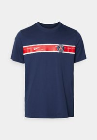 Tamsiai mėlynas medvilninis marškinėlis su raudona ir balta horizontalia juostele per krūtinę, ant priekinės pusės suapvalintu logotipu ir Nike emblema.