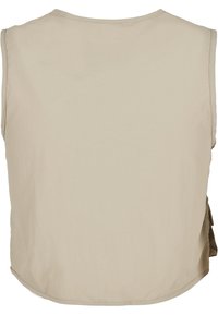 Beżowy top bez rękawów z zaokrąglonym dołem, miękka faktura materiału i mały detal w postaci bocznej kieszonki. Prosty design bez wzorów czy akcentów sprzętowych.