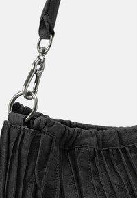 Borsa a mano in pelle nera con texture plissettata, dotata di una tracolla removibile, hardware in argento e un anello metallico circolare.