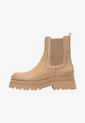Beige Knöchelschuh aus glattem Leder, mit elastischen Seitenpaneelen und einer robusten, griffigen Sohle für besseren Halt.