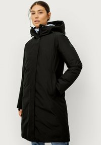 Zwarte, lange mouwen jas met een capuchon, gemaakt van een gladde, matte stof. Voorzien van een knoopsluiting en zijzakken. Eenvoudig ontwerp zonder zichtbare patronen.
