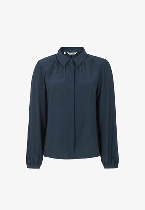 Temno modra bluzica z dolgimi rokavi in ovratnikom, s pokončno rebrasto teksturo in elastičnimi manšetami. Gumbi spredaj.