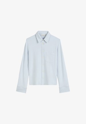 Lichtblauwe langslavenshirt van zachte stof, met een klassieke kraag, sluiting met knopen aan de voorkant en een enkele borstzak.