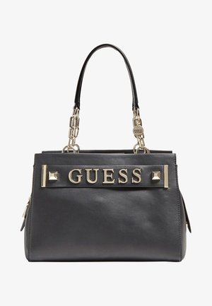 Czarna skórzana torebka Guess z złotymi uchwytami łańcuchowymi, złotymi literami logo z przodu oraz ozdobnymi złotymi ćwiekami.