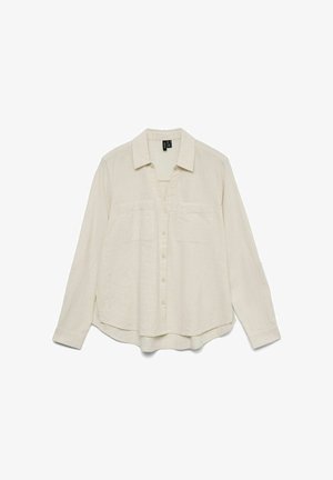 Krém színű, hosszú ujjú, gombos ing két mellzsebbel, klasszikus gallérral és enyhén ívelt alsó szegéllyel.