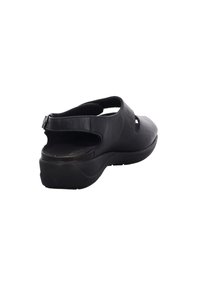 Black leather slingback shoe with cut-out design, padded footbed, and textured sole. Features adjustable strap for secure fit.