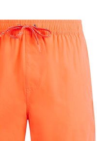 Shorts de bain orange vif avec une ceinture élastique et un cordon de serrage noué au centre avant.