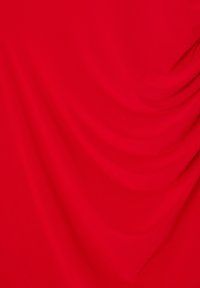 Tissu rouge à la texture lisse, présentant des plis et drapés doux qui créent une profondeur visuelle riche et une apparence vibrante.