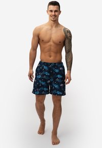 Heren zwemshorts in donkergroen met een tropische print van palmbomen en bergen. Beschikt over een elastische tailleband met een trekkoord en een logo-applicatie.