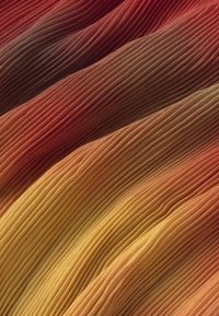 Tissu avec de fins plis verticaux dans des couleurs dégradées chaudes allant du jaune au rouge profond, créant un motif texturé et fluide.