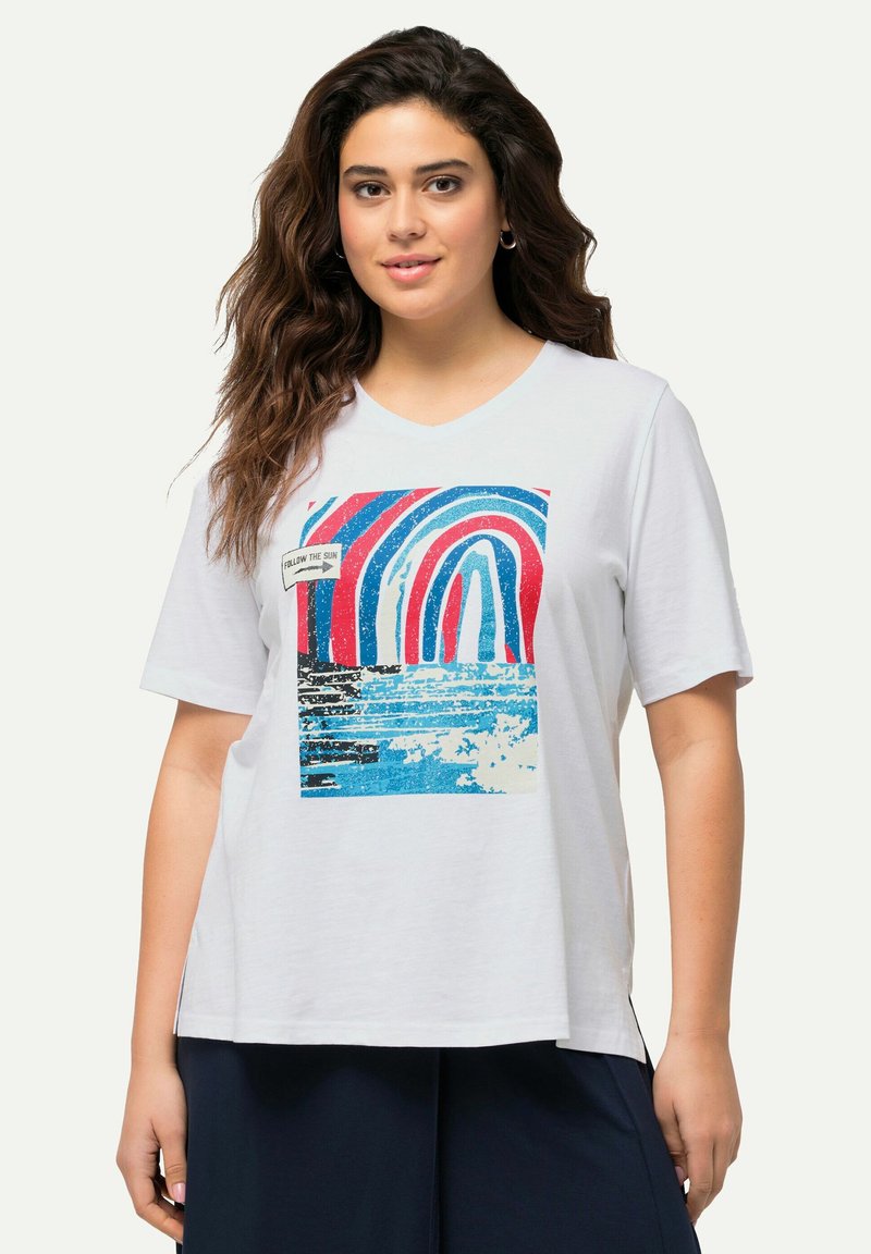 Witte katoenen t-shirt met een kleurrafische weergave van bogen in rood, blauw en zwart met de tekst "FOLLOW THE SUN" aan de voorkant.