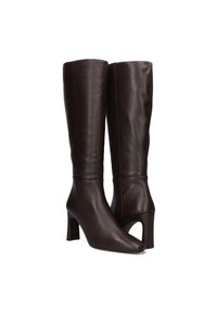 Bottes en cuir marron hauteur genou avec un bout pointu et un talon bloc. Présente une section ouverte à l'avant au-dessus du talon pour un design supplémentaire.
