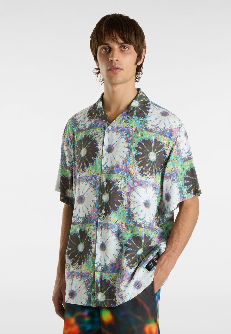 Camicia a maniche corte con bottoni, caratterizzata da un motivo grafico floreale in bianco e nero, su uno sfondo vivace e multicolore.