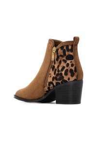 Stivale alla caviglia in suede marrone con pannello laterale a stampa leopardata, zip dorata e tacco nero a strati. Texture liscia e design a punta arrotondata.