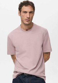Light pink short-sleeve crew neck t-shirt, made of soft fabric with a smooth texture. Simple design, no patterns or visible hardware.