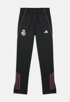 Black athletic pants made from synthetic material, featuring the Real Madrid logo and Adidas stripes in dark pink on the sides.