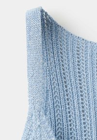 Tissu tricoté bleu clair avec un motif ajouré vertical et une bretelle tricotée unie sur la zone de l'épaule.