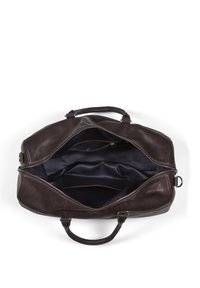 Braune Leder-Dufflebag mit zwei Griffen, Reißverschlussöffnung und marineblauem Innenfutter; verfügt über mehrere Innentaschen zur Organisation.