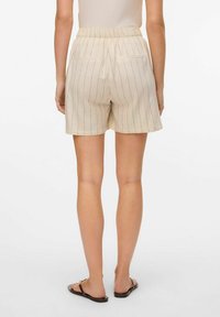 Beiga randiga shorts med en mjuk textur, elastisk midja och två bakfickor. Designade för komfort och avslappnad användning.