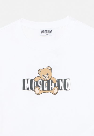 Λευκό παιδικό μπλουζάκι Moschino με γραφικό σχεδιασμό αρκουδάκι που κρατάει μαύρο-άσπρο κείμενο MOSCHINO.