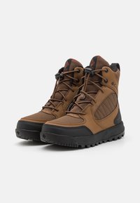 Braune Wanderschuhe mit einem Obermaterial aus Mesh und Synthetik, Gummisohle, gepolstertem Kragen und verstärktem Zehenschutz, mit schwarzen Akzenten.