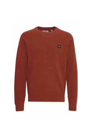 Suéter de color óxido hecho de tela acanalada, con escote redondo y mangas largas, y una pequeña etiqueta de marca negra en la parte frontal.