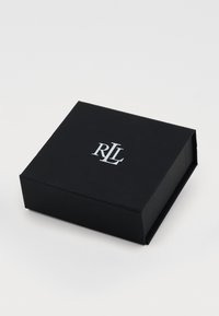Crna pravokutna kutija sa mat finishom, sa srebrnim logotipom "RL" na vrhu. Nema vidljive opreme ili dodatnih uzoraka.