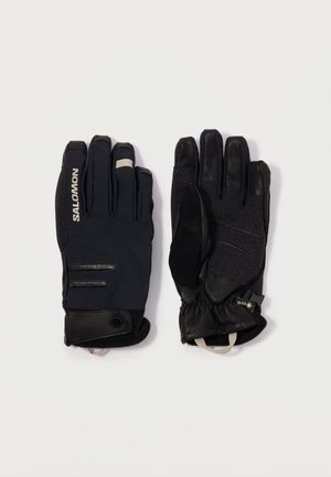 Black gloves featuring a mix of textured fabric and leather. Notable details include rubber accents and a snug cuff for warmth and fit.