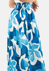 Falda larga en azul y blanco con patrón floral, que presenta una cintura elástica fruncida y un tejido ligero y texturizado.