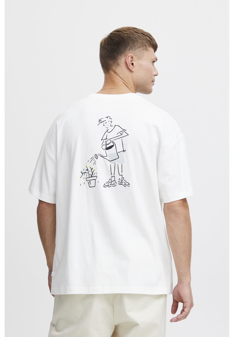Hvid bomulds T-shirt med en sort stregtegning på ryggen, der skildrer en person, der vander en plante. Kortærmet og afslappet pasform.