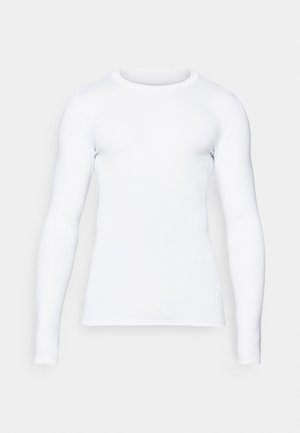 Fehér hosszú ujjú ing sima anyagból, kerek nyakkivágással és testhezálló fazonnal, minimális varrási részletekkel az illesztések mentén.