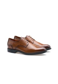 Bruine leren schoenen met een gladde textuur, ronde neus, vetersluiting en een contrasterende zwarte rubberen zool.