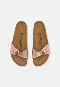 Sandales à glissière métalliques roses avec une seule boucle ajustable. Semelle en liège avec une surface texturée pour le confort. Taille visible : 38.