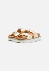 Gold metallic slide sandals with two wide straps and a single buckle accent, featuring a cork footbed and thick white rubber outsole.