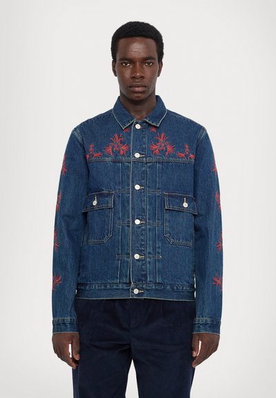 Blue denim jacket featuring red floral embroidery, snap buttons, and two front pockets. Classic collar and structured fit. Textured fabric.