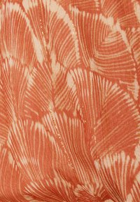 Texturiert fabric in Koralle mit weißen Blattmustern und subtilen goldenen Akzenten, die ein geschichtetes, organisches Design schaffen.