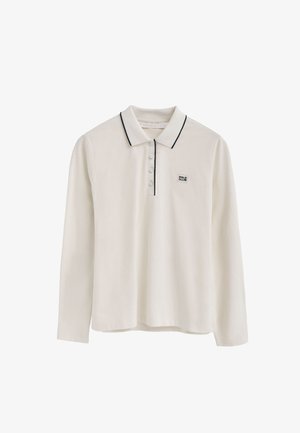 Polo à manches longues en coton écru, avec un col, une patte de boutonnage à trois boutons et un liseré noir le long du col et des manches.