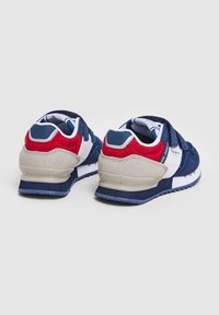 Sininen ja punainen lenkkari, jossa on tarranauha, päällä mokkaa ja verkkomateriaalia, valkoisia yksityiskohtia ja kumipohja. "Pepe Jeans" -merkintä kantapäässä.