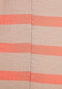 Textilie s horizontálními pruhy v broskvové a korálové barvě na béžovém pozadí, s m ěkkým, texturovaným povrchem.