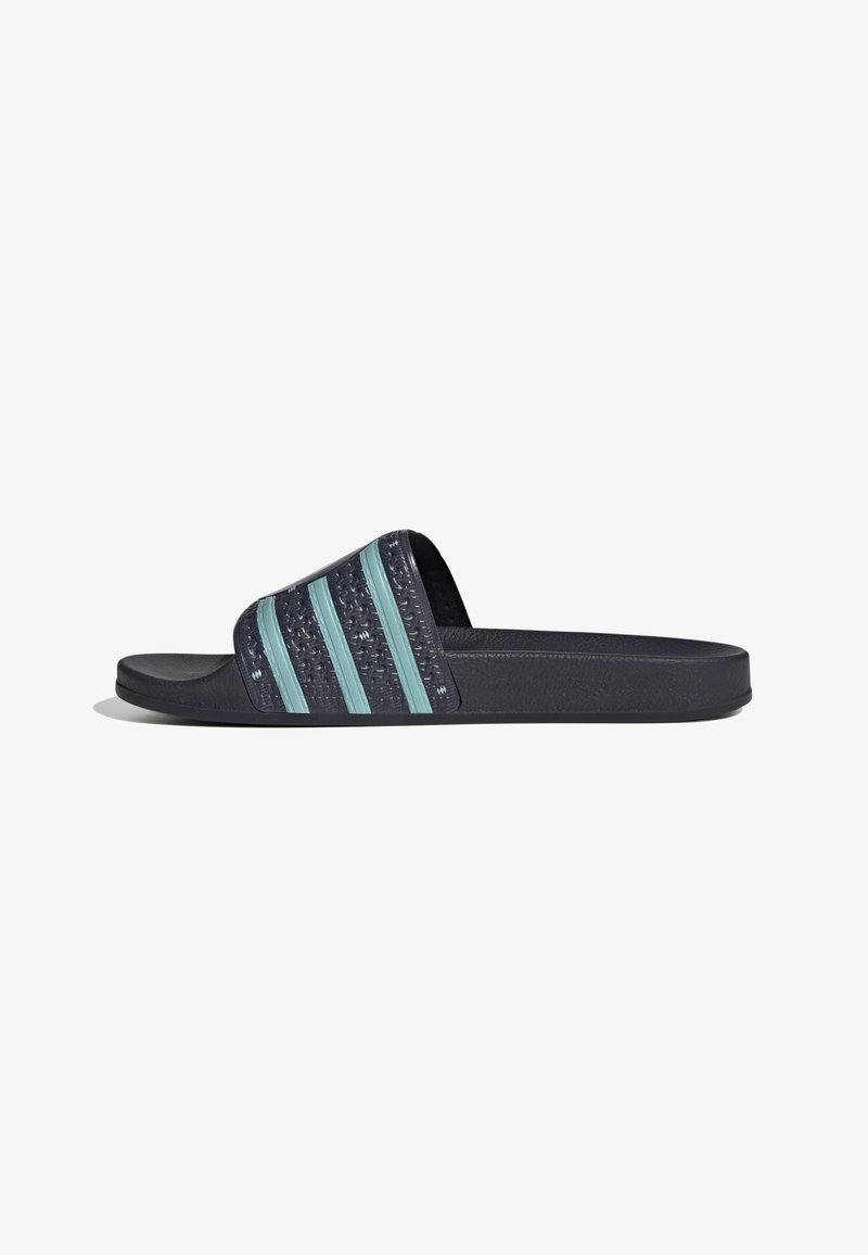 Sandale slide noire avec trois bandes turquoise sur la large bride texturée et semelle plate, vue de profil sur fond blanc.