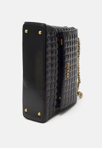 Sac à main en simili cuir matelassé noir avec quincaillerie dorée, chaîne en strap et forme carrée. Présente un logo de marque en relief et des rivets décoratifs.