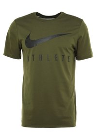 Olivgrön t-shirt med kort ärm och svart Nike swoosh-logotyp samt texten "ATHLETE" över bröstet, designad med rundad hals.