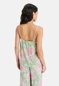Floral tank top in green with pink and white patterns, featuring thin straps and a loose, flowing design, suitable for casual wear.