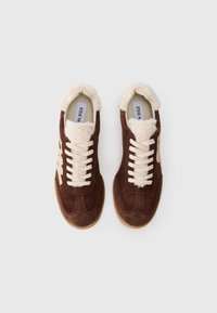 Brown suede sneakers with cream faux fur trim, cream laces, and a gum sole. Features a subtle logo and a classic athletic silhouette.