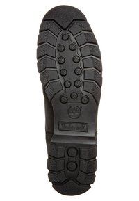 Semelle de botte en caoutchouc noir avec des motifs de profil profond, présentant des éléments de traction circulaires et hexagonaux ainsi qu'une empreinte du logo Timberland.