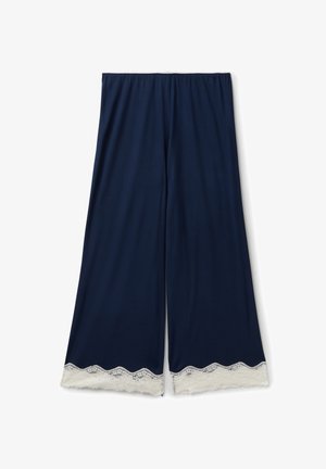 Marineblauwe wijde broek met witte kanten rand aan de zoom, met een elastische tailleband, plat neergelegd op een witte achtergrond.