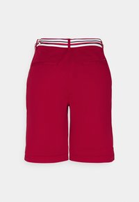 Pantalones cortos rojos con una textura suave, que presentan una cintura elástica a rayas en azul, blanco y rojo, y dos bolsillos traseros.