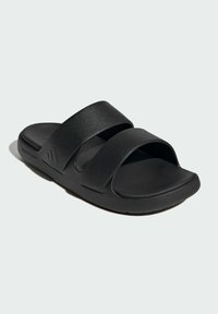 Sort slidesandal med to brede syntetiske remme. Blød, polstret sål og tekstureret ydersål. Minimalistisk design uden yderligere detaljer.